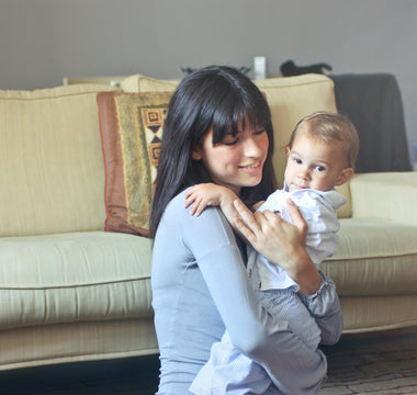 World Breastfeeding Week, mom holding her baby, sitting on the couch